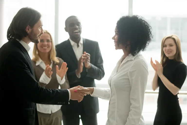 Grateful boss handshaking and promoting employee — KORE1 direct hire staffing and career placement services