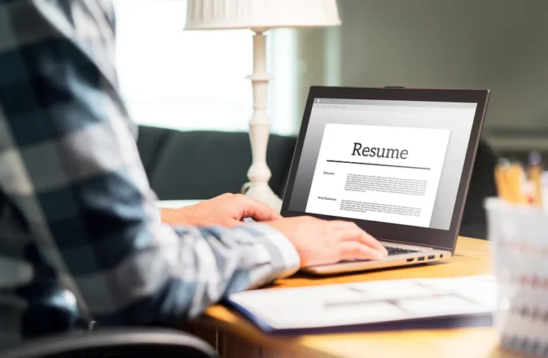 Man writing resume and CV at home — KORE1 career resources and job placement services for IT and engineering professionals