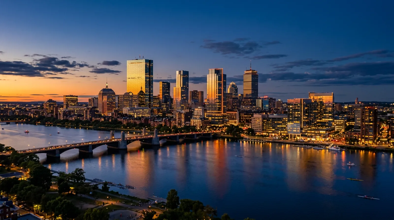 Boston skyline at dusk with modern glass towers reflecting golden light over the Charles River
