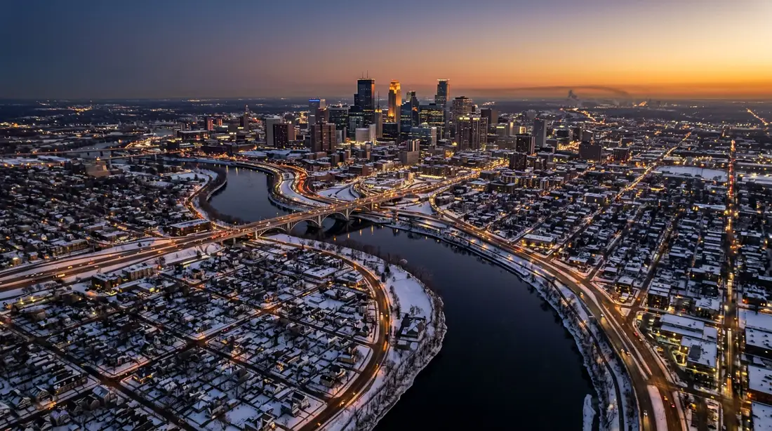 Aerial twilight view of the Minneapolis Saint Paul metro showing the Mississippi River and downtown skyline