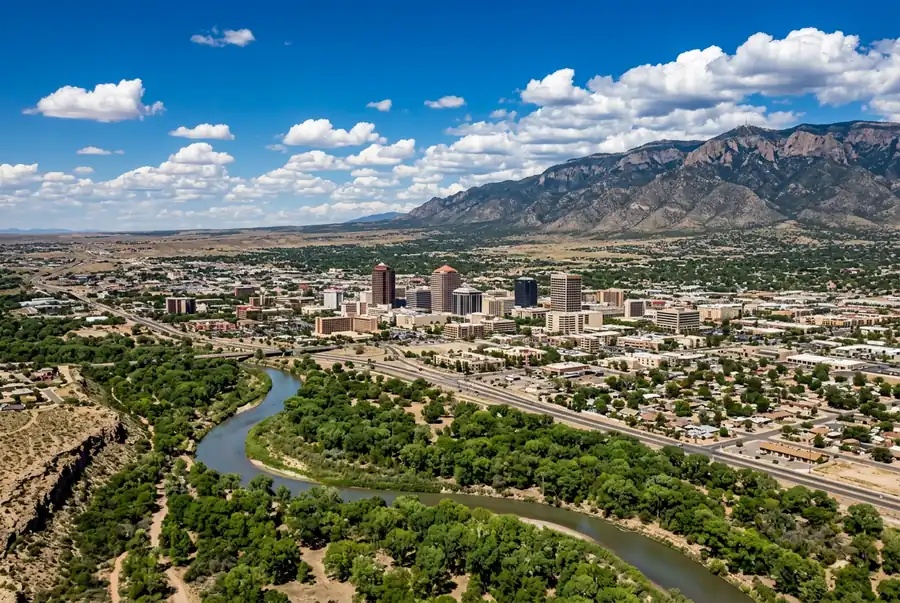 Aerial daytime view of Albuquerque New Mexico showing the downtown skyline the Rio Grande curving through the valley and the Sandia mountains rising on the eastern horizon