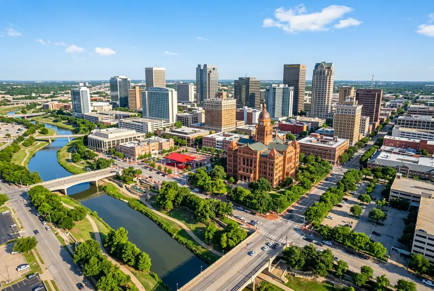 Aerial daytime view of downtown Fort Worth Texas with the Tarrant County Courthouse, Sundance Square, and the Trinity River visible against a bright Texas sky
