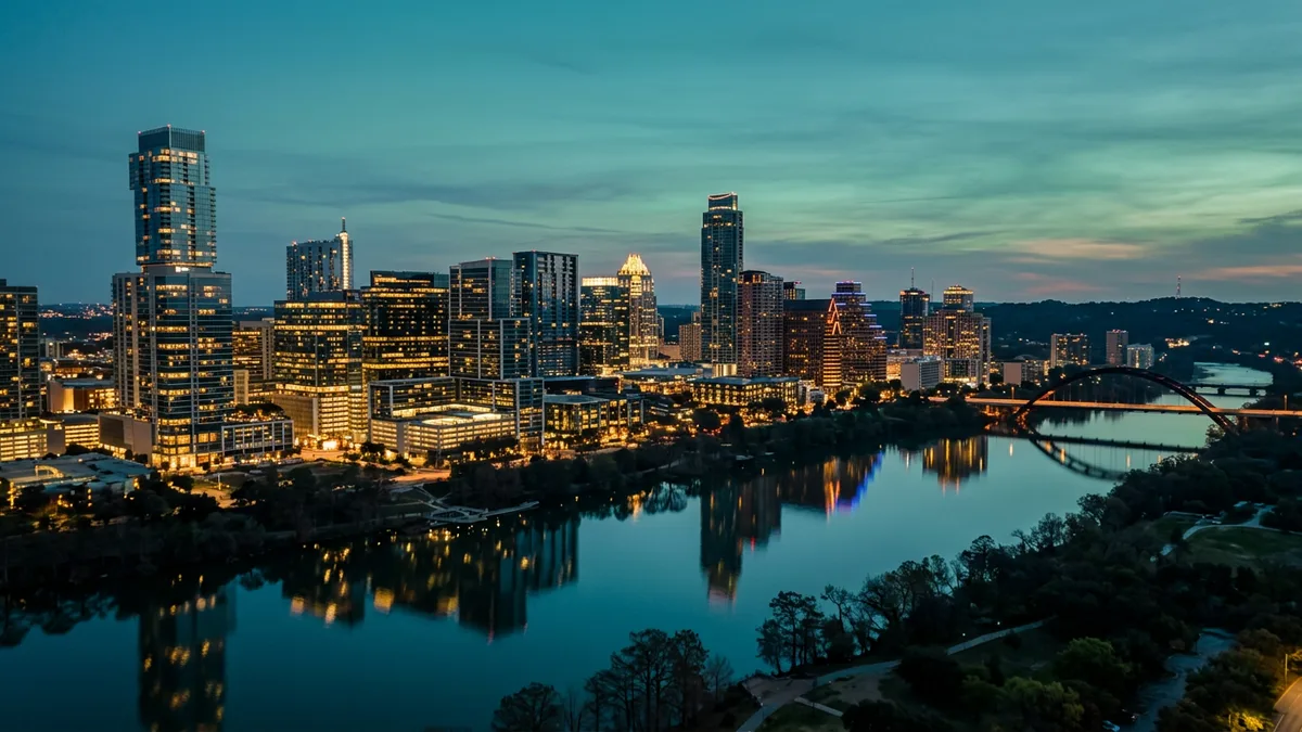 Downtown Austin skyline and Lady Bird Lake lit at blue-hour dusk, the metro KORE1 serves for cybersecurity staffing