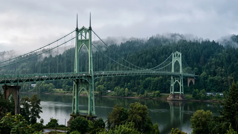 The green Gothic towers of Portland's St. Johns Bridge rising over the Willamette River, the Douglas firs of Forest Park in the misty hills behind