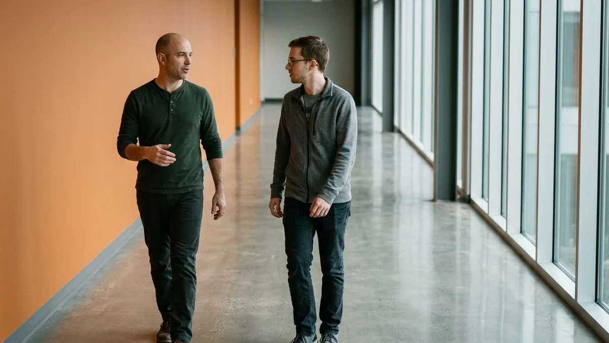 Engineering lead walking with a contract developer during a check-in about what finished work should look like by next week