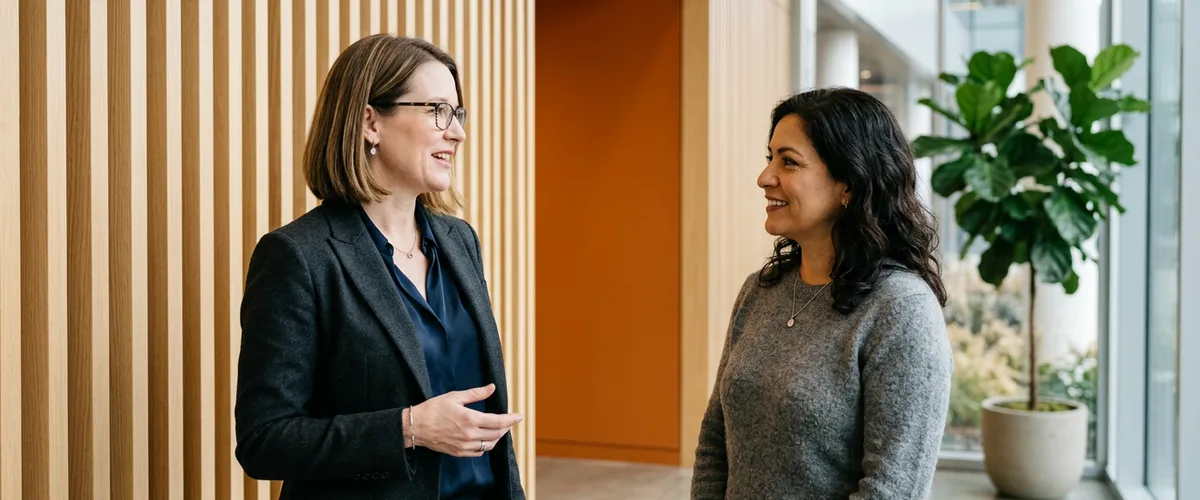 Two data leaders in a modern office lobby discussing whether to hire contract or full-time for their data team