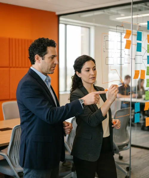 Two engineering leaders at a whiteboard mapping SOC 2 control ownership across their team