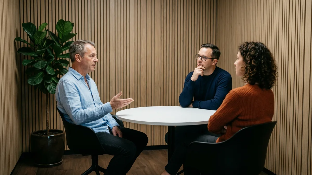 CTO explaining system decisions to two reviewers from an acquiring company during technical due diligence
