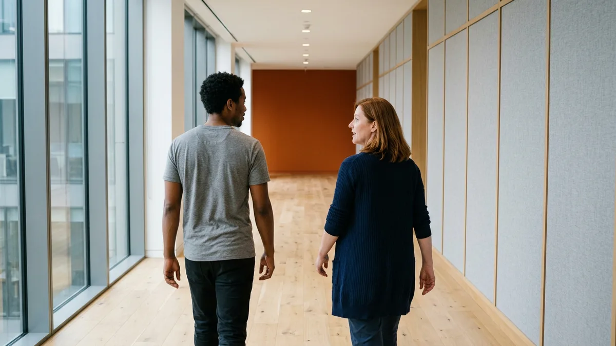 Contract help desk technician walking an office aisle with the office manager during an onsite shift